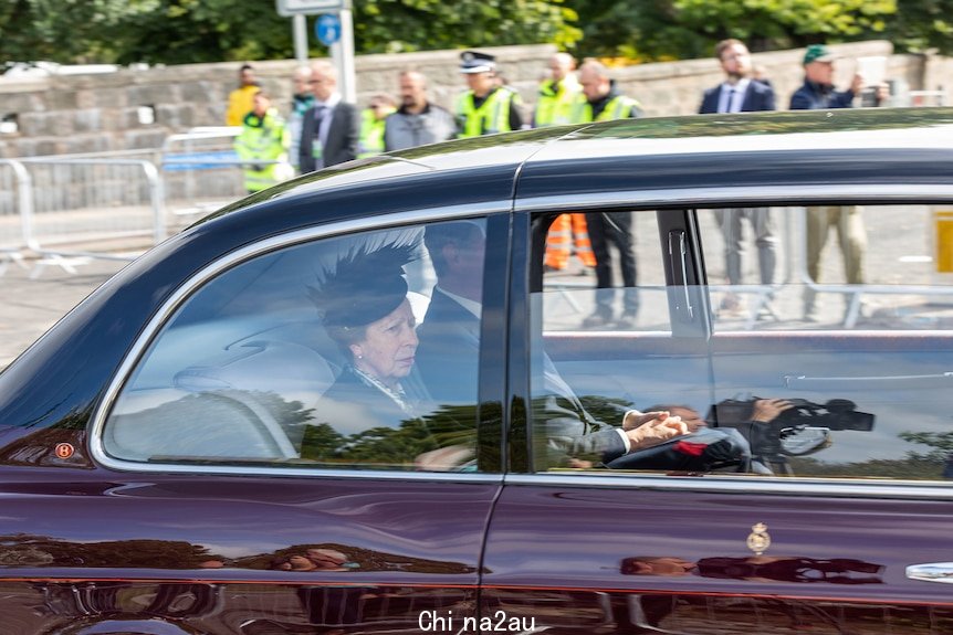 Princess Anne sits in the back of a car.