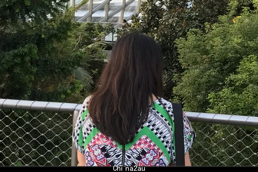 A woman stands in a garden.