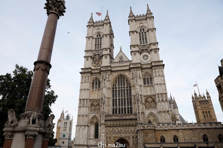 An ornate cathedral with flags flying at half mast.