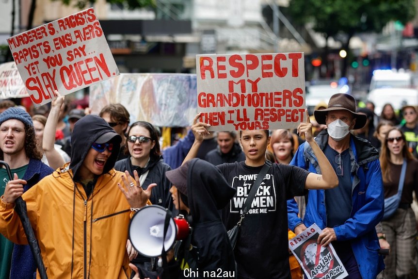 Protesters are seen marching down Elizabeth St in Brisbane City.