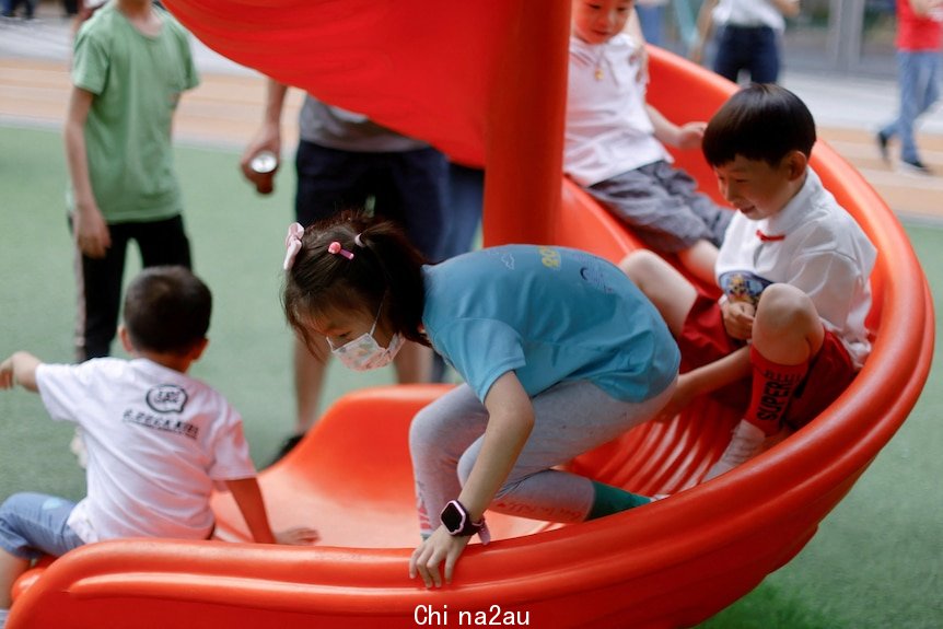 A group of Chinese children play on a slide
