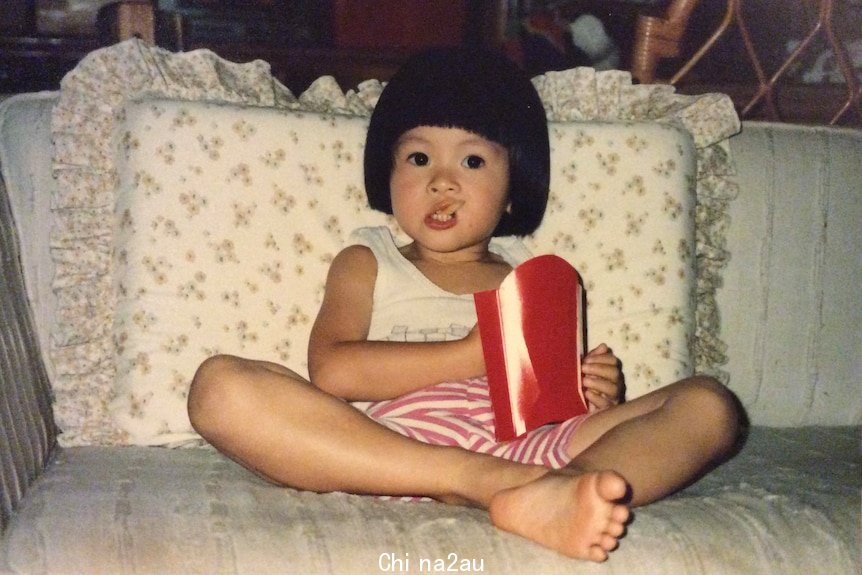 一个梳着童花头的小女孩坐在沙发上吃薯条