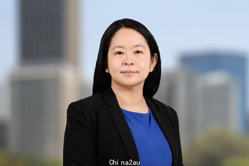 Chinese-Indonesian woman in business attire smiling to camera.