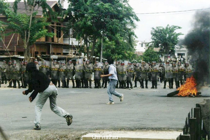 Protesting students throw stones at Indonesian riot police.