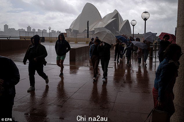 悉尼地区、Illawarra 和周日早上可能进入 Hunter 的风速可能达到 70-90 公里/小时(如图,人们在他们参观悉尼的悉尼港海滨时躲避大雨和大风)