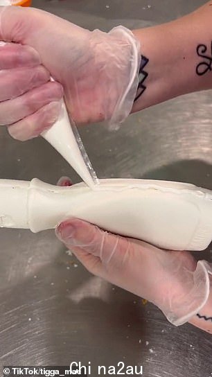 然后她用更多融化的白巧克力将两半融合在一起,贴在两个可食用标签上
