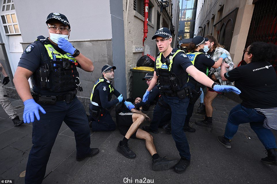 在墨尔本的反君主制抗议活动中,警察看到一名男子倒在地上,活动人士在 CBD 游行