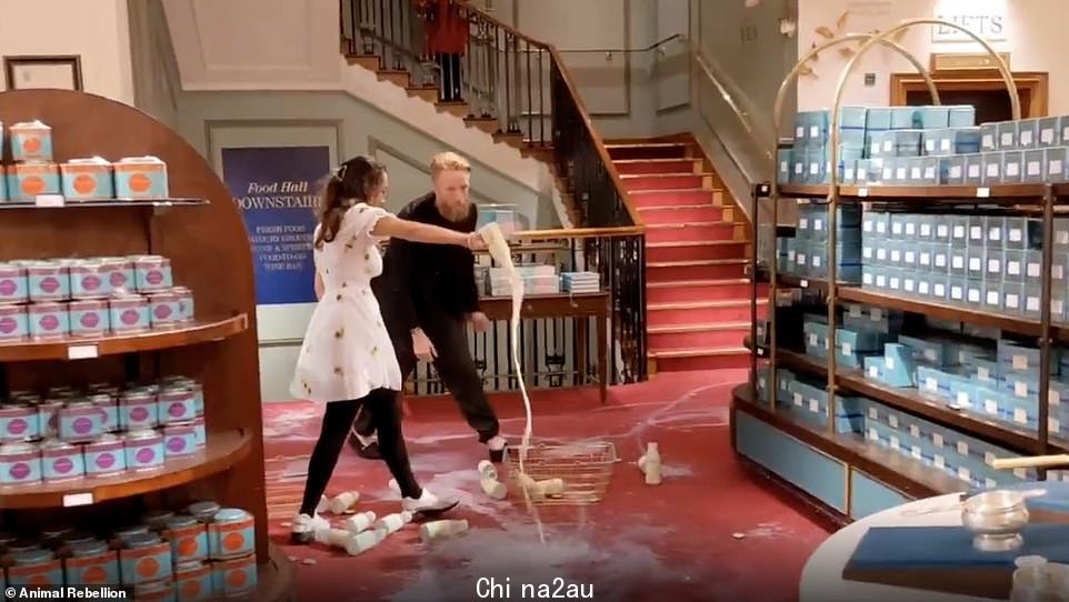 留胡子的男人和穿着白色连衣裙的女人在 Fortnum & Mason 举行抗议活动