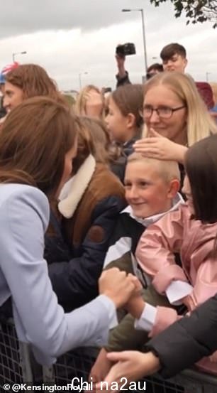 取而代之的是，这对夫妇分享了皇室成员会见小学生（左右）的片段，他们举着横幅欢迎他们来到该地区