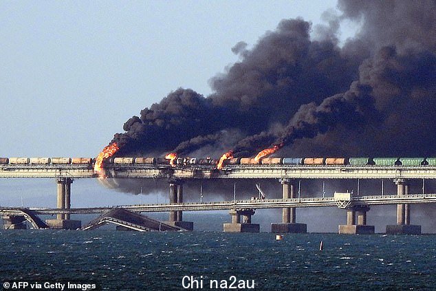 这张照片显示了俄罗斯和克里米亚之间唯一的铁路和公路连接所造成的惊人破坏,在一次巨大的爆炸使燃料列车着火并导致下面的道路跨度坍塌之后