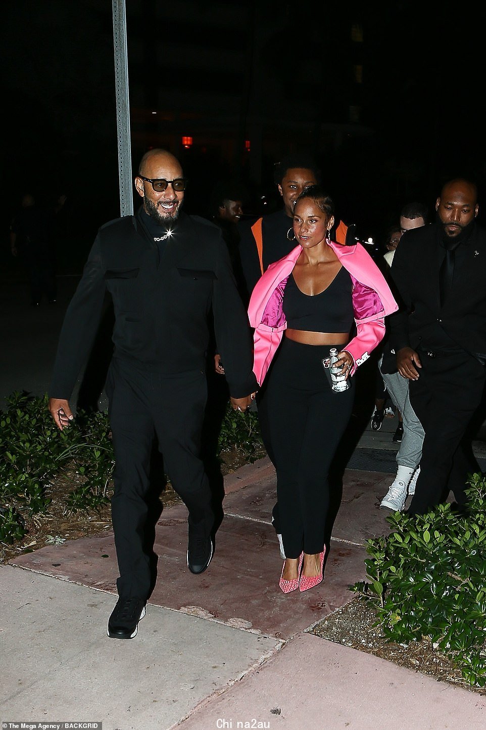 Casual: Alicia Keys穿着亮粉色羽绒夹克,外搭黑色运动文胸和裤子组合。她由丈夫 Swizz Beatz 陪同,他设计了一条闪亮的钻石链,黑色纽扣和裤子