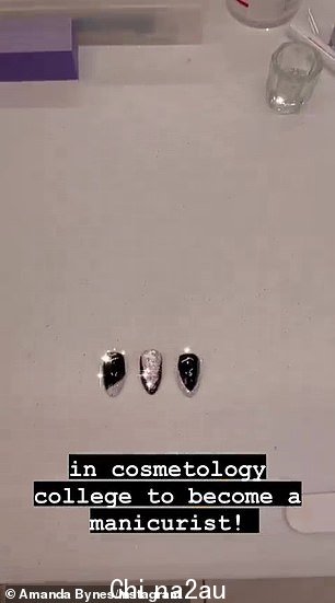 她展示了三个银色和黑色亚克力指甲