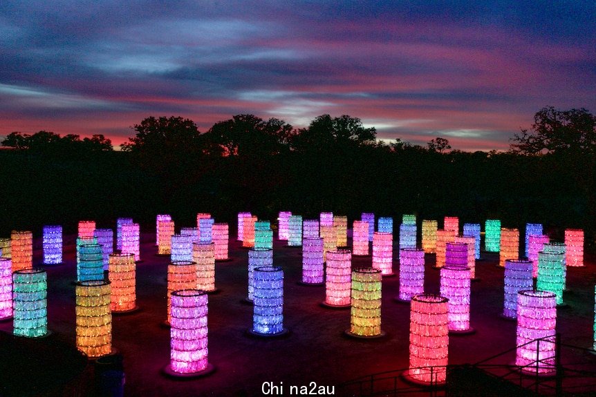 Rows of coloured lanterns illuminated against a dark sky.