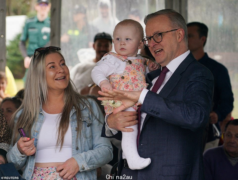 澳大利亚总理 Anthony Albanese 在纪念巴厘岛爆炸案 20 周年的追悼会上与受害者家属交谈时抱着 1 岁的 Capria Thompson