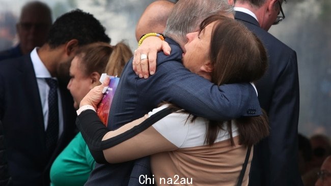 在追悼会结束时，看到一个心烦意乱的女人与 Albanese 先生拥抱。图片：Lisa Maree Williams/Getty Images