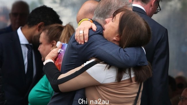 在追悼会结束时,看到一个心烦意乱的女人与 Albanese 先生拥抱。图片:Lisa Maree Williams/Getty Images