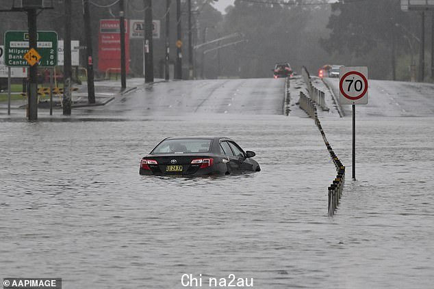 A car is seen abandoned in floodwaters on Newbridge Road in Chipping Norton in Western Sydney in July. Parts of NSW are also expecting floods
