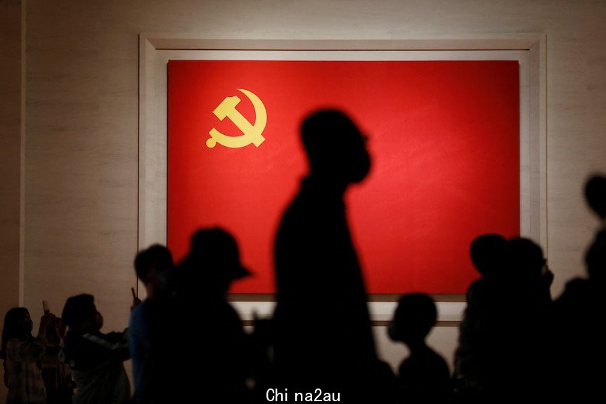 The shadows of people standing in front of a CCP flag