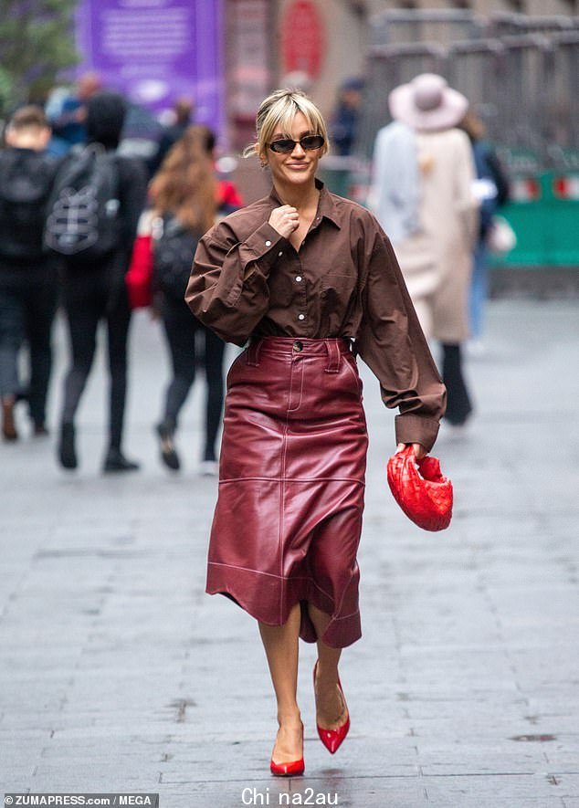 Fashionista:41 岁的联合主演和前猫咪玩偶 Ashley Roberts,穿着超大号棕色衬衫和醒目的红色不对称皮革拼接裙子,看起来非常时尚