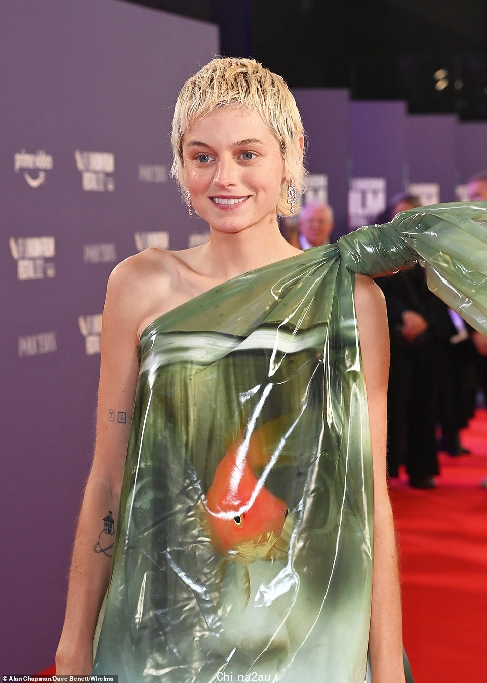 Glamour puss: Emma 独自站在红地毯上,她的搭档 Harry Styles 因巡演冲突没有出席活动