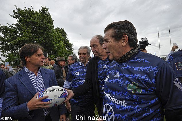 总统o f 乌拉圭,Luis Lacalle Pou(左)在橄榄球友谊赛前与安第斯山脉悲剧的幸存者 Fernando Parrado(中)和 Carlos Paez(右)交谈。这些人是业余橄榄球队的一员,乘坐命运多舛的航班