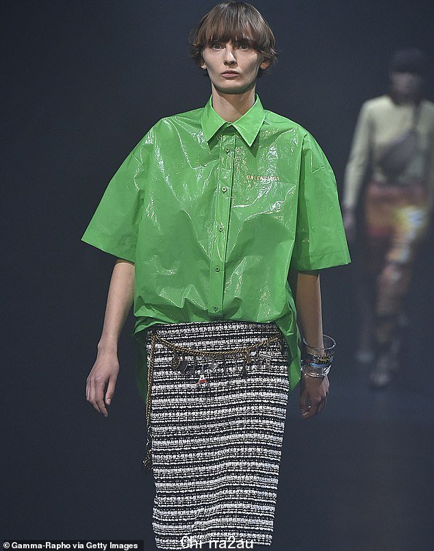 Balenciaga 将上衣称为“Plastic-Bin 衬衫”,上面印有品牌的衬衫正面和背面均以粗体金色字母标识
