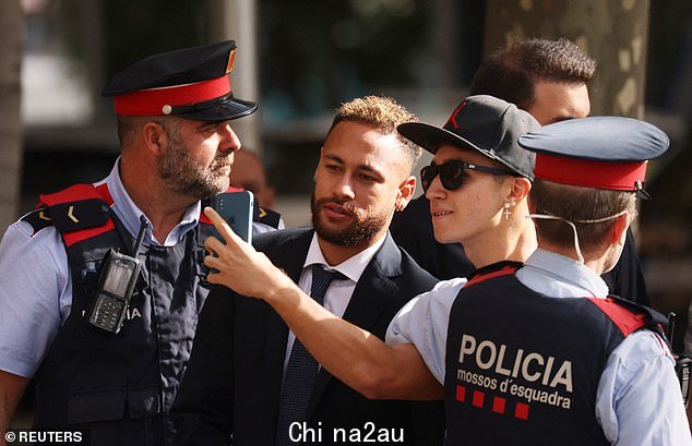 图:周二内马尔抵达巴塞罗那球场时,西班牙警察站在内马尔身边,一名球迷在自拍