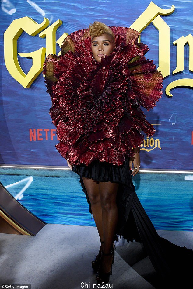 Showstopping:在红地毯上,同样迷人的 Janelle 也加入了她的行列,她在戏剧性的红色迷你连衣裙
