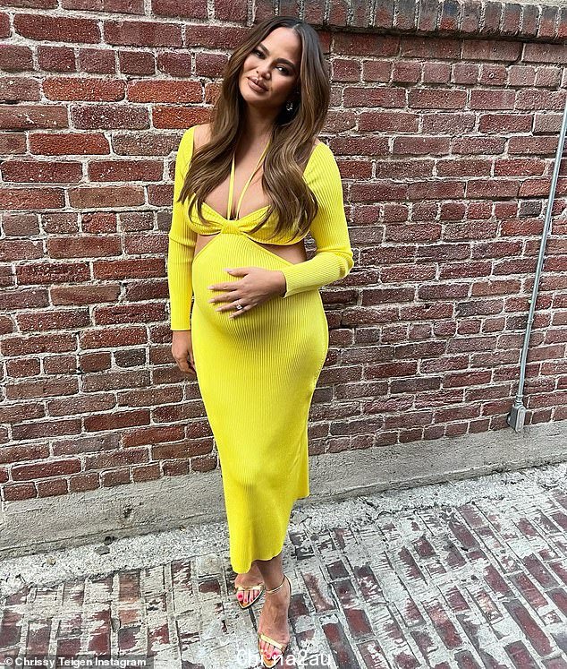 Glow: 周五,怀孕的 Chrissy Teigen 抱着她越来越大的肿块,她穿着鲜艳的黄色连衣裙为一张新的 Instagram 照片摆姿势