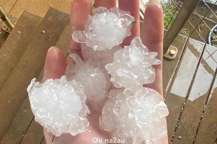 A hand holding five hail stones