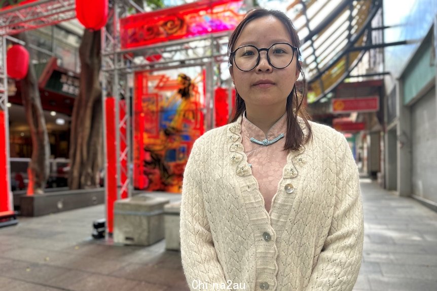 A woman stands in a street.