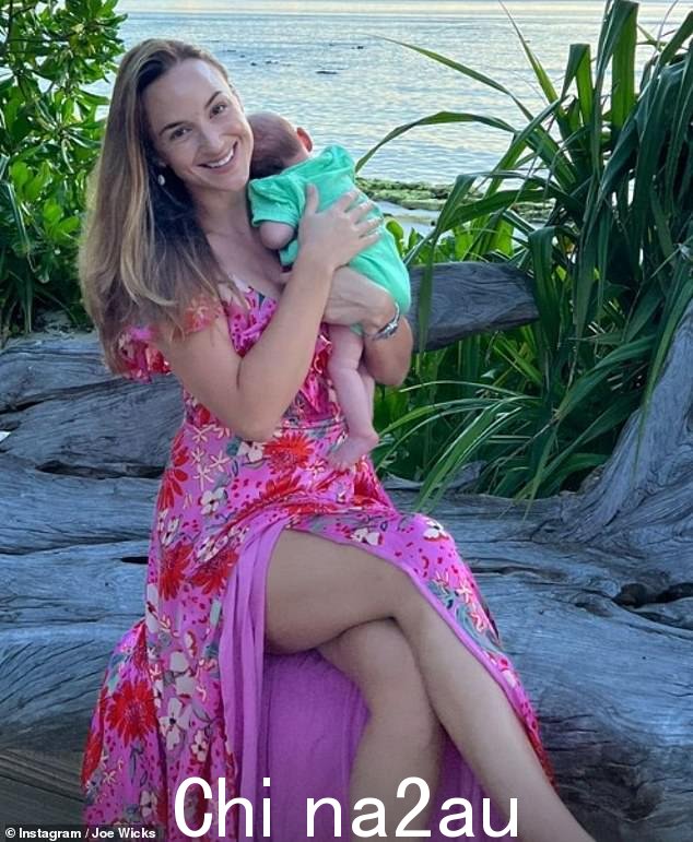 惊艳:其中一张照片显示 Rosie 抱着她的小女儿,身着亮丽的粉色碎花连衣裙