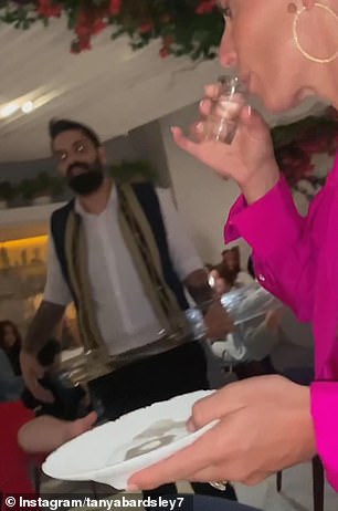 华丽:这位美女穿着一件深红色的粉红色迷你连衣裙,搭配一双高耸的裸色高跟鞋和迷人的妆容
