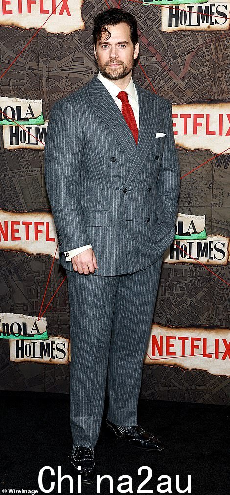 Dapper: Cavill 身着灰色细条纹西装,展现了他肌肉发达的超级英雄般的身材,看起来很整洁