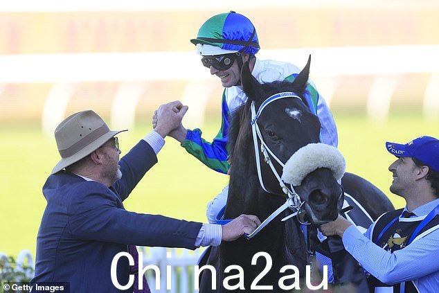 Luke Nolen(骑马)和训练师 Peter Moody(左)在 I Wish I Win 在 Randwick 拿下价值 1000 万美元的金鹰奖后拥抱