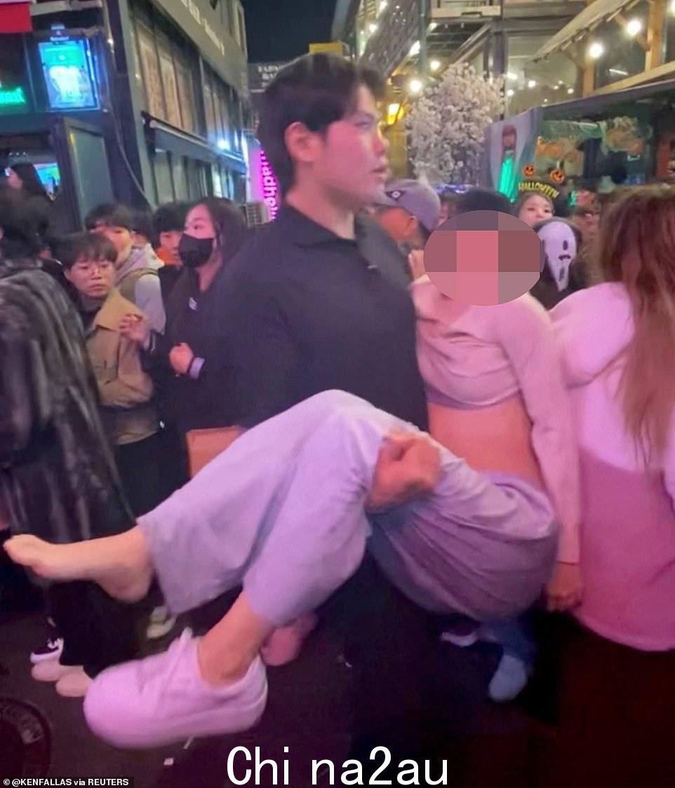 一名筋疲力尽的年轻女子被卷入当晚的事件后被抬离现场安全