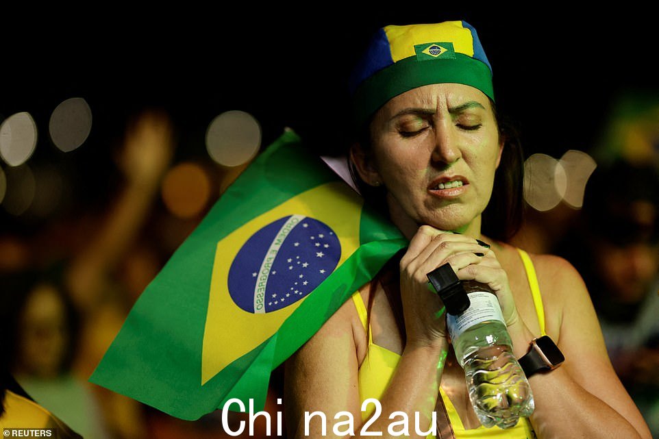巴西总统和总统候选人 Jair Bolsonaro 的支持者在巴西巴西利亚举行的巴西总统选举决选期间举着巴西国旗