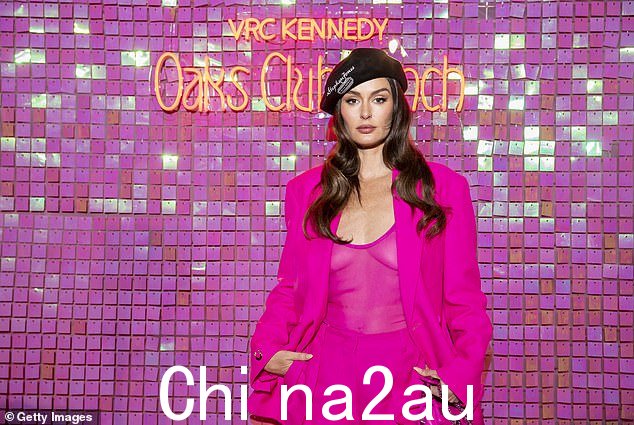 这位 36 岁的澳大利亚-意大利模特身穿华伦天奴 (Valentino) 粉色西装,半透明上衣搭配阔腿裤
