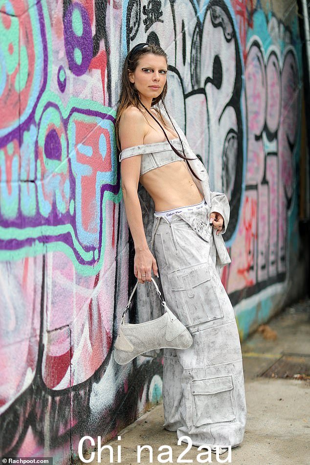 她和她的 Calvins: The Uncut Gems 女演员在低腰解开松垮的灰白色裤子中闪现她的 Calvin Klein 内衣
