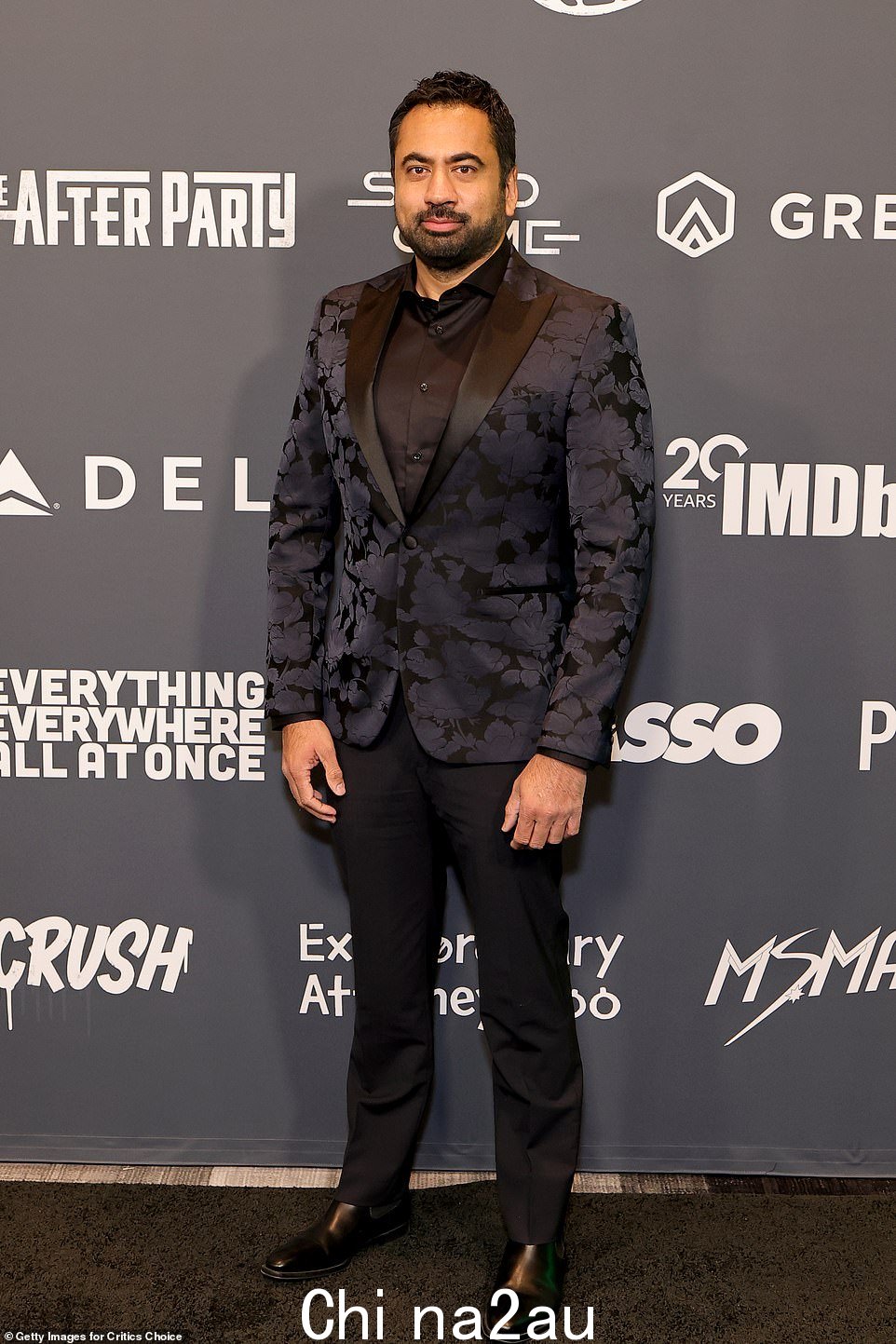 时尚:我是怎么认识你的你的母亲明星 Kal Penn 在黑色衬衫和黑色休闲裤上穿着带有花朵印记的紫色西装外套