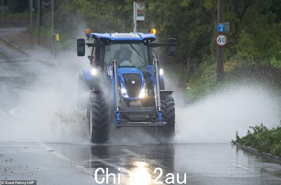在肯特郡 Leybourne 的道路上轻松处理一个非常大的水坑的拖拉机