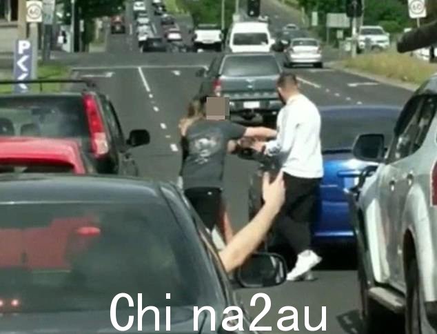 一个小男孩,据信是该女子的儿子,冲下车阻止一名男子与她对质