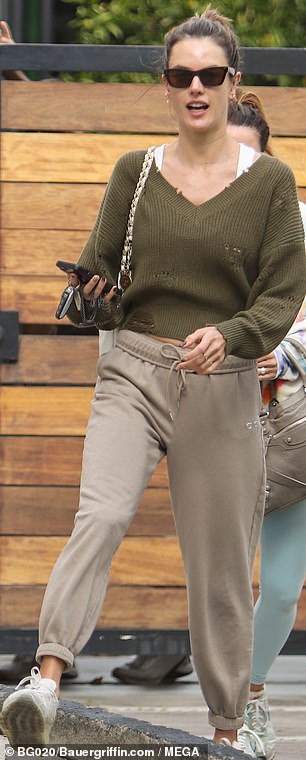 Legging it: 这位 41 岁的超级名模暗示她穿着一件苔绿色毛衣,带有深 V 领的令人羡慕的紧绷的腹部