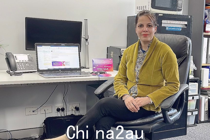 Sonia Kalsi sitting on a chair in an office. 