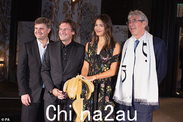 Emma 和其他与会者——包括 Dior 的首席执行官兼董事长 Pietro Beccari(左二)也被拍到了——他们在 Harrods 的设计师装置前合影留念