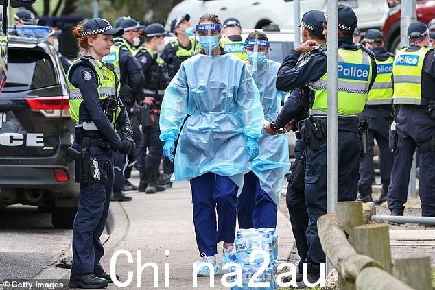昆士兰州首席医疗官约翰杰拉德博士表示,当前的浪潮可能会在圣诞节前一周达到顶峰,并警告说 Covid 浪潮的周期可能会持续“多年”(如图,2020 年墨尔本全副 PPE 的医务人员)