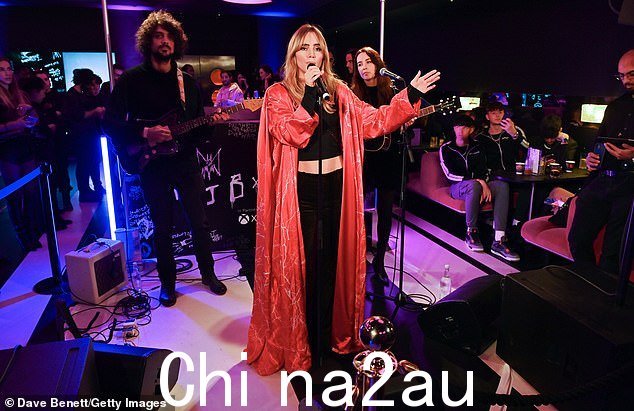 Chic: 这位美女身穿低腰丝绒长裤和黑色短款T恤,外搭大胆的红色夹克