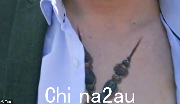 随着戏剧性的音乐播放,他拉开衬衫露出他的纹身,这似乎是幸存者奖杯