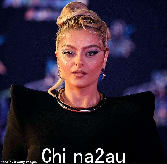在城里:Bebe 出生在布鲁克林,父母是来自南斯拉夫的阿尔巴尼亚移民,她选择了一件光滑的黑色长袍,凸肩