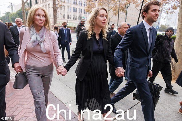 大腹便便的福尔摩斯和她的家人走进去时保持沉默o 法院大楼,与她的搭档比利·埃文斯 (Billy Evans) 手牵着手。她将不得不在 4 月 27 日自首